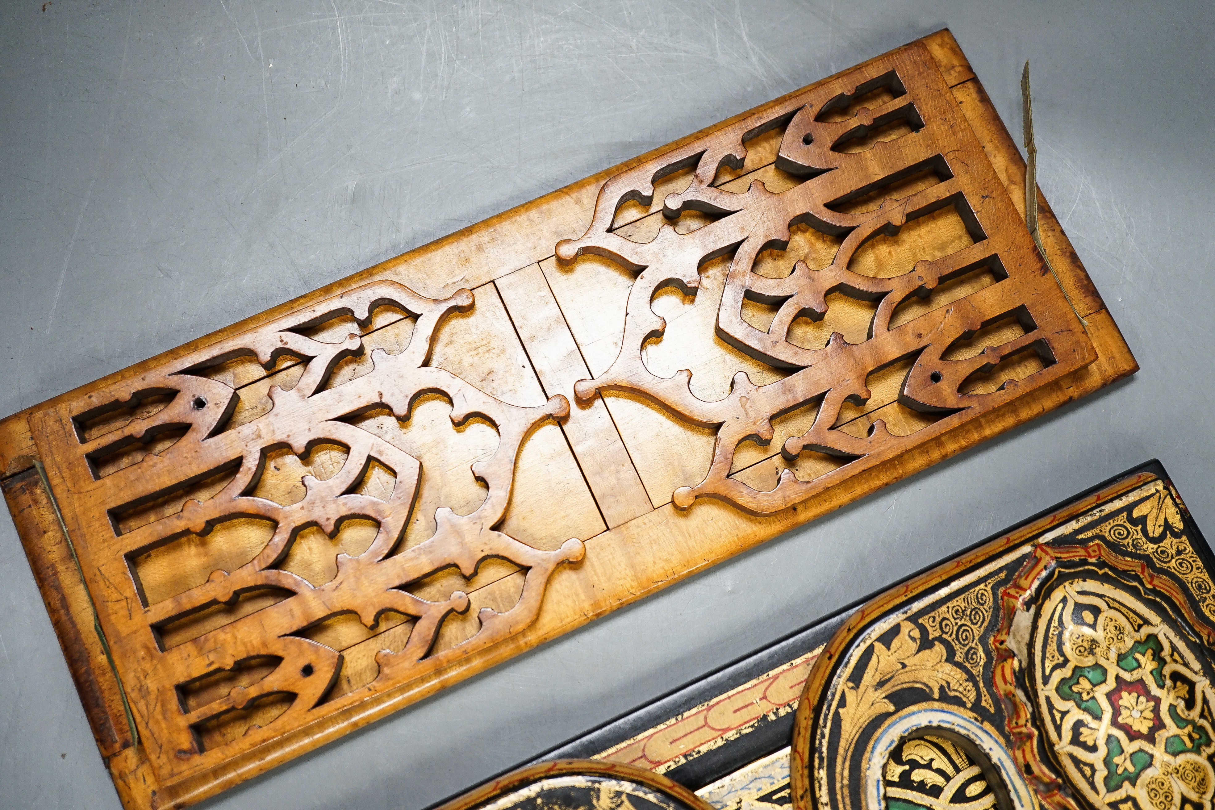 A Victorian Pugin style Gothic revival bird’s eye maple bookslide together with a japanned papier-mâché example (2), largest 34cms wide.